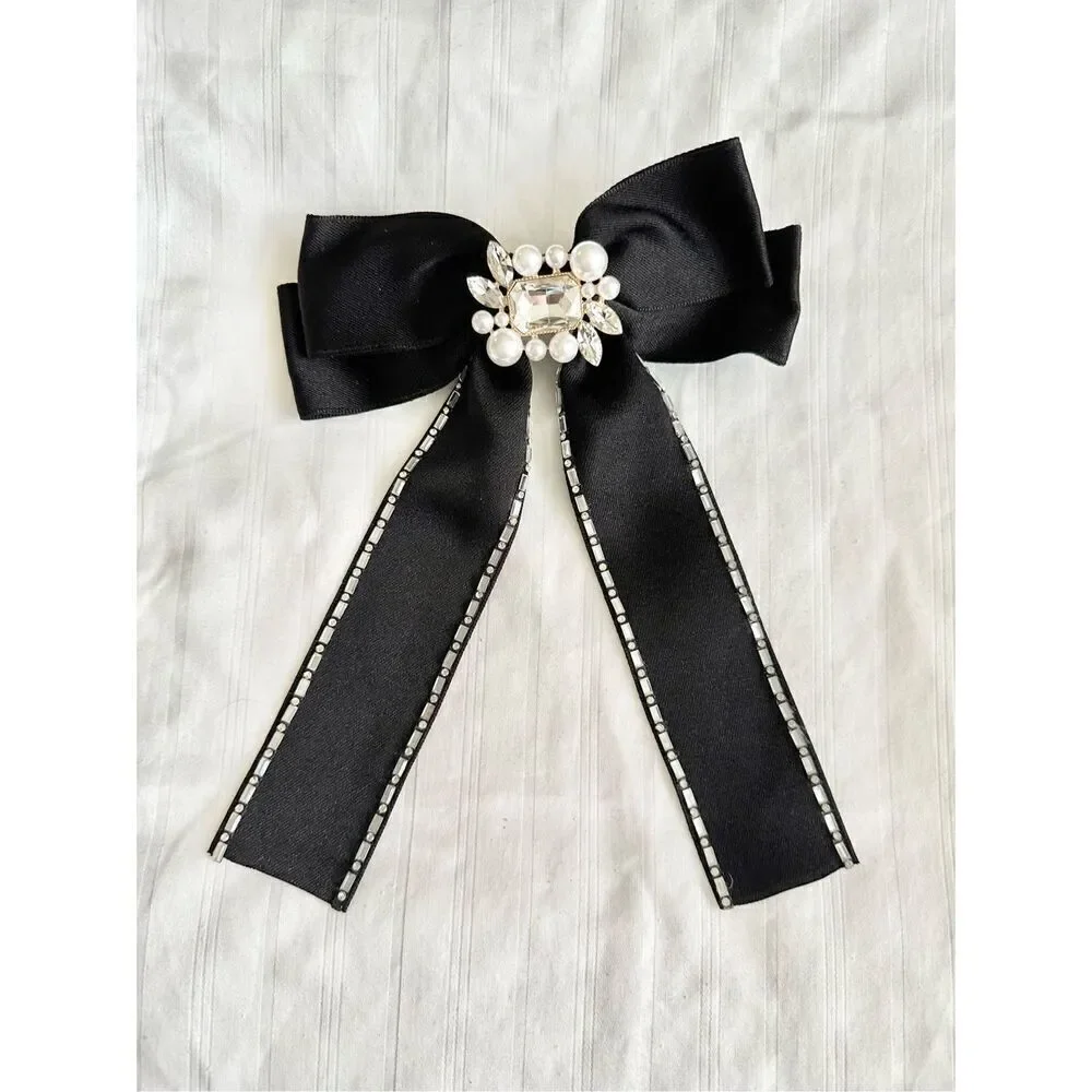 Black satin hair bow with rhinestone embellishment and pearl ￼